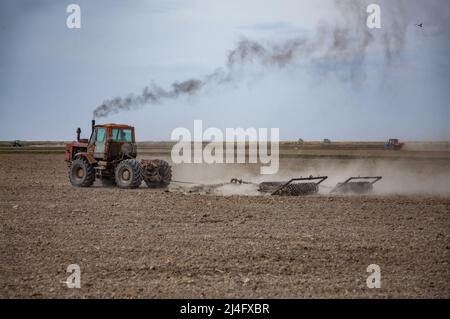 Provincia di Kyzylorda, Kazakistan - 01 maggio 2019: Terreno coltivato a trattore con aratro. Stagione di semina primaverile. Foto Stock