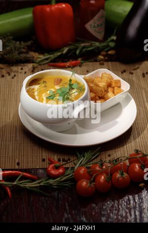 Fotografia verticale con deliziosa zuppa in piatto bianco con cracker. Foto Stock