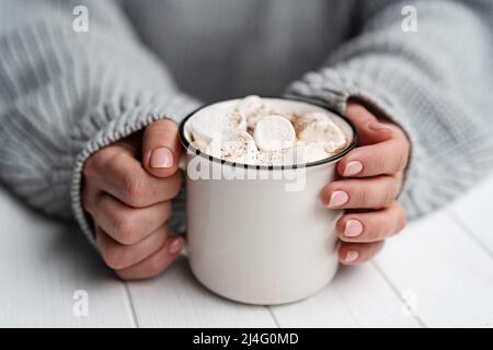 Donna che tiene una tazza con cacao e marshmallow Foto Stock