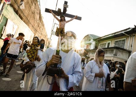 Navotas, Filippine. 15th Apr 2022. Una donna porta un Crocifisso di Gesù Cristo il Venerdì Santo in Navotas. Molti cattolici filippini segnano la settimana Santa sottomettendosi a diverse forme di penitenza fisica nella speranza di essere perdonati per i loro peccati. Credit: SOPA Images Limited/Alamy Live News Foto Stock