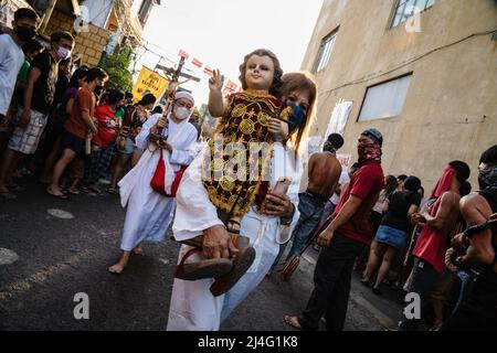 Navotas, Filippine. 15th Apr 2022. Una donna cammina lungo la strada portando una statua il Venerdì Santo in Navotas. Molti cattolici filippini segnano la settimana Santa sottomettendosi a diverse forme di penitenza fisica nella speranza di essere perdonati per i loro peccati. (Foto di Oliver Haynes/SOPA Images/Sipa USA) Credit: Sipa USA/Alamy Live News Foto Stock