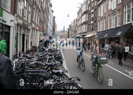 Vista su una delle strade classiche di Amsterdam piena di biciclette e turisti Foto Stock