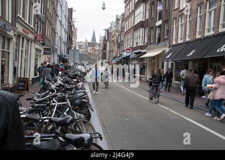 Vista su una delle strade classiche di Amsterdam piena di biciclette e turisti Foto Stock