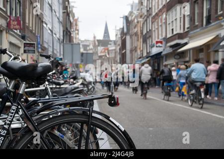 Vista su una delle strade classiche di Amsterdam piena di biciclette e turisti Foto Stock