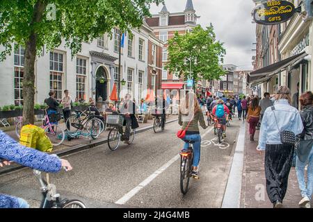 Vista su una delle strade classiche di Amsterdam piena di biciclette e turisti Foto Stock