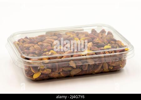 Pistacchi impaccati su sfondo bianco. Pistacchi confezionati per la vendita al banco del mercato. Primo piano Foto Stock