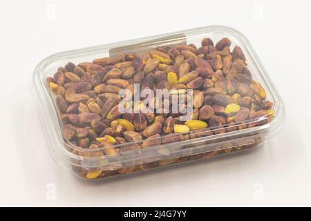 Pistacchi impaccati su sfondo bianco. Pistacchi confezionati per la vendita al banco del mercato. Primo piano Foto Stock