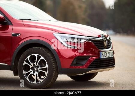 Berlino - Marzo 2022: 2021 Renault Arkana e-Tech ibrido SUV auto tre quarto lato destro vista anteriore all'aperto parcheggiato in strada vicino alla foresta. Foto Stock