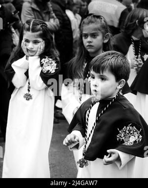 Elche, Spagna - 13 aprile 2022: I bambini in parata pasquale con portieri e penitenti per le strade della città di Elche nella settimana Santa Foto Stock