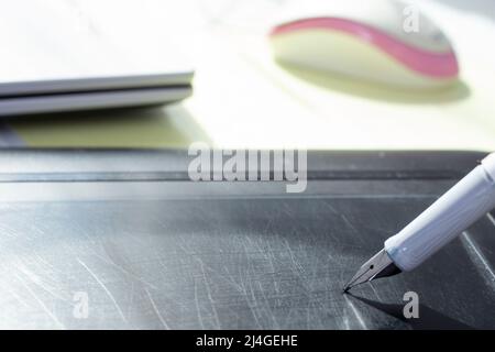 Scrivere con una penna stilografica su una tavoletta grafica, con graffi sulla superficie Foto Stock