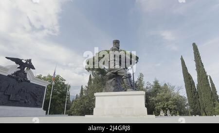 Monumento di pietra ad Alessandro il terzo. Azione. Un bel monumento girato in estate intorno a un parco e grandi alberi di abete. Foto Stock