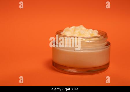 Crema viso in un bicchiere cosmetico su sfondo colorato Foto Stock