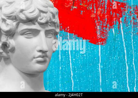 statua in gesso bianco contro un muro con vernice rossa e blu. Foto di alta qualità Foto Stock