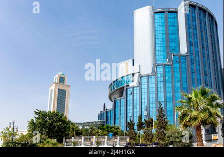 Sonatrach AVAL e Grande Moschea Abdelhamid Ibn Badis minareto. Sede della ditta Sonatrach, una vista ad angolo basso degli edifici moderni. Foto Stock