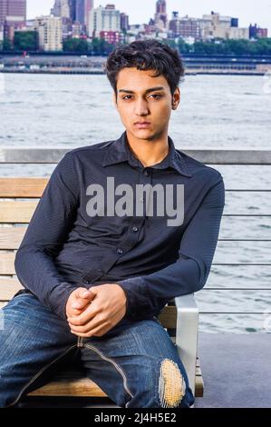 Ritratto di 18 anni adolescente indiano-americano a New York City. Giovane studentessa che indossa una camicia nera a manica lunga, jeans alla moda spezzati, sit Foto Stock