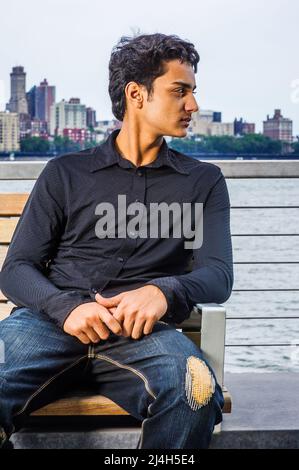 Ritratto di 18 anni adolescente indiano-americano a New York City. Giovane studentessa che indossa una camicia nera a manica lunga, jeans alla moda spezzati, sit Foto Stock