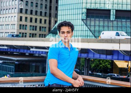 Ritratto di 18 anni adolescente indiano-americano a New York City. Giovane studente universitario maschio che indossa una camicia a manica corta blu, in piedi all'esterno Foto Stock