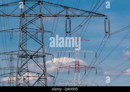 Tralicci metallici che trasportano cavi elettrici sospesi di linee ad alta tensione. Concetti di reti di trasmissione elettrica, alimentazione di energia, consumo di energia Foto Stock