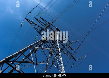 Traliccio metallico che trasporta cavi elettrici sospesi di linee ad alta tensione. Concetti di reti di trasmissione elettrica, alimentazione di energia, consumo di energia Foto Stock