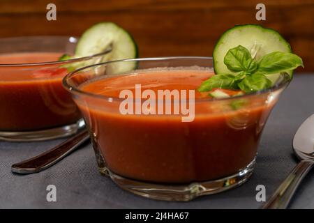 Recipiente in vetro trasparente con Gaspacho Andaluz. Una zuppa vegetale e biologica o una bevanda fredda che viene bevuta in estate o nelle giornate calde. Vista Hig. Primo piano. Foto Stock