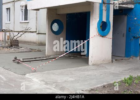 Nuovo edificio di appartamenti con area cieca in cemento. Area cieca recintata con nastro barriera rosso-bianco. Processo di formazione della zona cieca della fondazione, pavimentazioni in calcestruzzo Foto Stock