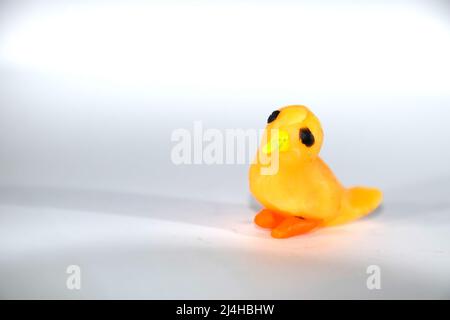 Un piccolo pulcino giallo. Uccello plasticina su sfondo bianco. Foto Stock