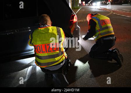 Singen am Hohentwiel, Germania. 15th Apr 2022. Gli ufficiali di polizia controllano un Volkswagen Golf sintonizzato tirato fuori da un controllo del traffico sul cosiddetto Venerdì auto. Tradizionalmente, la scena dei tuner e dei possessori di auto si incontra il Venerdì Santo nella zona di Villingen-Schwenningen e Singen am Hohentwiel. Credit: Felix Kästle/dpa/Alamy Live News Foto Stock