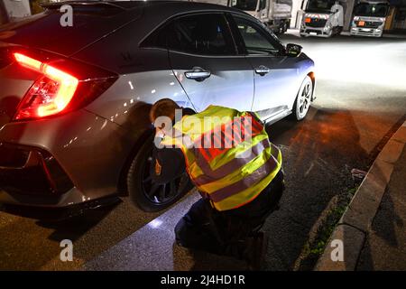 Singen am Hohentwiel, Germania. 15th Apr 2022. Un funzionario di polizia controlla una macchina tirata fuori da un controllo del traffico sul cosiddetto Car Friday. Tradizionalmente, la scena dei tuner e dei possessori di auto si incontra il Venerdì Santo nella zona di Villingen-Schwenningen e Singen am Hohentwiel. Credit: Felix Kästle/dpa/Alamy Live News Foto Stock