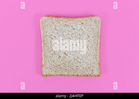 Fette di pane tostato al grano di farro su sfondo rosa Foto Stock