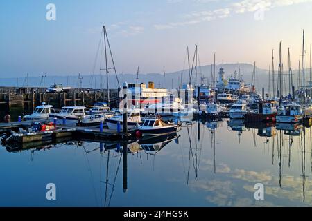 Regno Unito, North Yorkshire, Scarborough Harbour e Lighthouse at Sunset Foto Stock