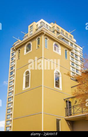 Facciata con finestre ad arco bianche in un edificio giallo. Elementi di decorazioni architettoniche di edifici in New Westminster BC. Foto di strada, nessuno, Foto Stock