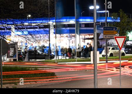 Singen am Hohentwiel, Germania. 15th Apr 2022. I fan della scena di sintonizzazione si incontrano in una stazione di servizio. In precedenza, la polizia aveva controllato alcuni veicoli sintonizzati lì. La stazione di servizio è un popolare luogo di incontro per la scena di sintonizzazione sul Car Friday, come i tuner chiamano Venerdì Santo. (Scatto con esposizione prolungata.) Credit: Felix Kästle/dpa/Alamy Live News Foto Stock