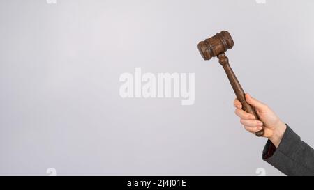 Donna che tiene il gavel del giudice su sfondo bianco. Foto Stock