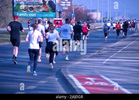 Vista posteriore del gruppo di persone che corrono maratona di strada Foto Stock