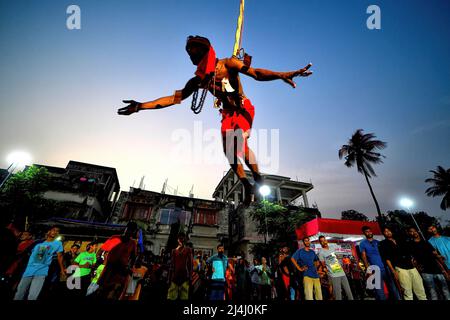 Kolkata, India. 15th Apr 2022. Un devotee indù visto appeso con un gancio durante la celebrazione di Charak Puja. Il Festival di Charak è uno dei più antichi festival Folkloristici come i devoti mostrano la loro fede da soli infliggendo dolore nella convinzione che Lord Shiva li aiuterà a superare i problemi nella loro vita quotidiana. Credit: SOPA Images Limited/Alamy Live News Foto Stock