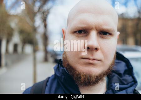 Un uomo bianco con testa calva e barba ha un riposo in un parco Foto Stock