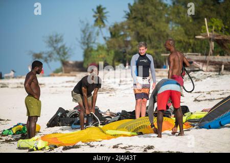 Zanzibar, Tanzania - Aprile 20,2022: I turisti si godono in kiteboarding sulle spiagge sabbiose di Zanzibar. Foto Stock