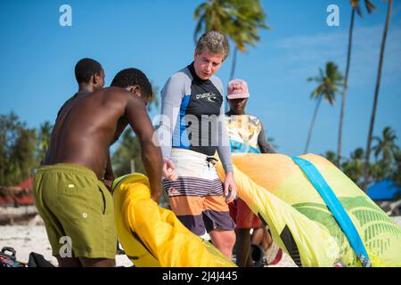 Zanzibar, Tanzania - Aprile 20,2022: I turisti si godono in kiteboarding sulle spiagge sabbiose di Zanzibar. Foto Stock