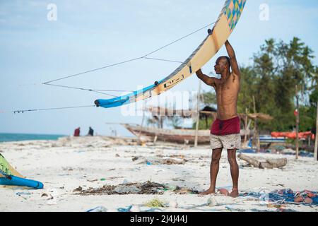 Zanzibar, Tanzania - Aprile 20,2022: I turisti si godono in kiteboarding sulle spiagge sabbiose di Zanzibar. Foto Stock