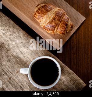 Tazza bianca piena di caffè e croissant, vista dall'alto Foto Stock