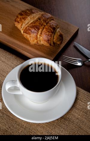 Tazza bianca piena di caffè e croissant, vista dall'alto Foto Stock