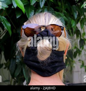 Dietro la testa di una donna bionda che indossa occhiali da sole e scrunchie Foto Stock