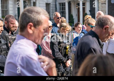 Gli ufficiali di polizia e i membri del pubblico osservano un minuto di silenzio in un servizio commemorativo per il WPC Yvonne Fletcher a St James Square a Londra. Data foto: Sabato 16 aprile 2022. Foto Stock