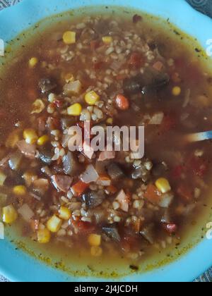 una zuppa con verdure, mais e salsicce in una ciotola Foto Stock