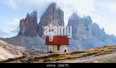 Uno dei panorami più famosi e spettacolari di tutte le Alpi: Il rifugio locatelli, la sua chiesa e le tre cime di Lavaredo Foto Stock