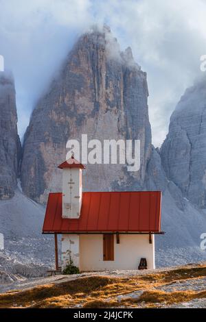 Uno dei panorami più famosi e spettacolari di tutte le Alpi: Il rifugio locatelli, la sua chiesa e le tre cime di Lavaredo Foto Stock