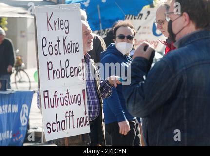 16 Aprile 2022, Renania Settentrionale-Vestfalia, Duisburg: All'inizio della marcia di Pasqua Reno/Ruhr, un partecipante chiede un poster 'la guerra non risolve alcun problema! Il riarmo ne crea di nuovi». Foto: Roland Weihrauch/dpa Foto Stock