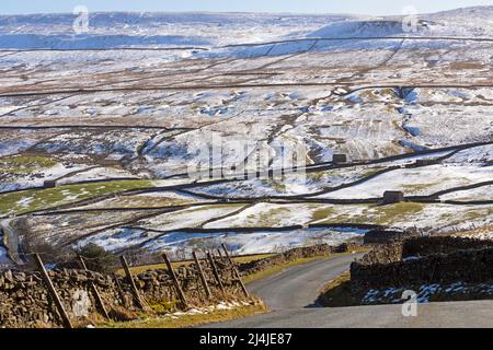 Curve ripide su B6270 in una giornata invernale a Swaledale, Yorkshire Dales National Park. La neve copre le campane sopra la valle vicino a Keld. Foto Stock