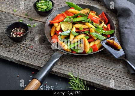 Gnocchi di patate a forma di dita con verdure fresche in una padella di ferro Foto Stock