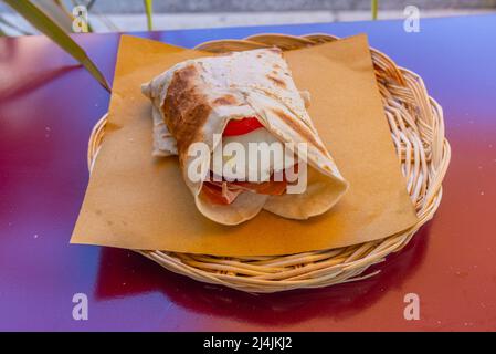 Piada sandwitch in un cestino su un tavolo. Foto Stock